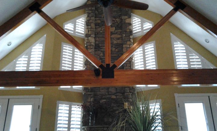 Angled windows on tan wall with brick divider.